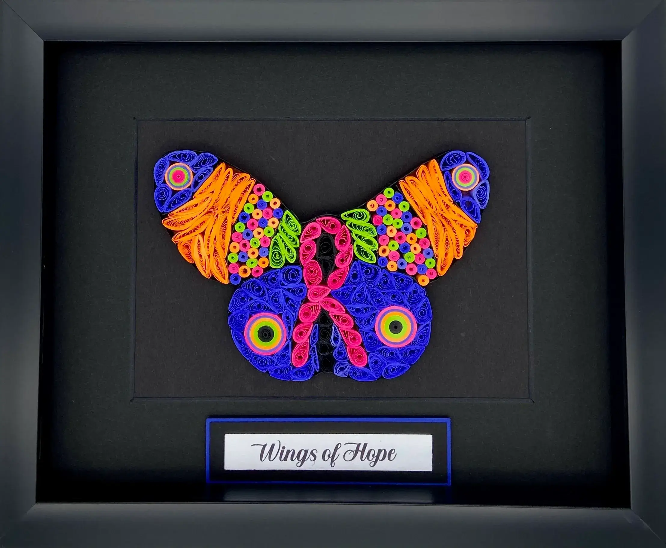 Colorful butterfly art made from woven threads, titled 'Wings of Hope'.