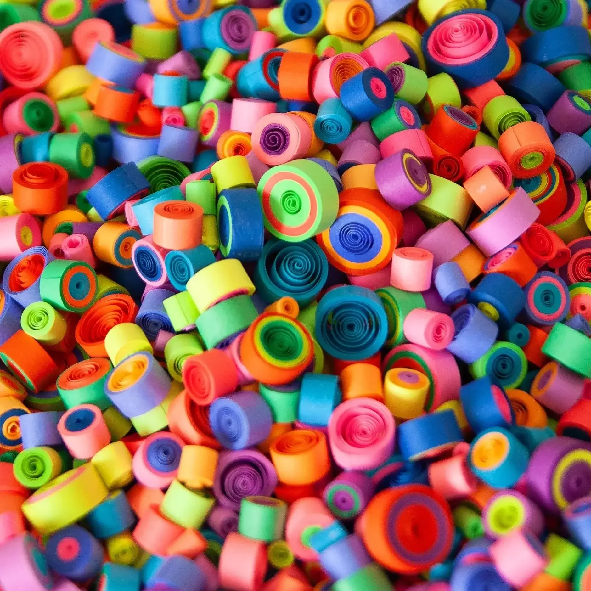 A colorful assortment of small plastic rings scattered together.